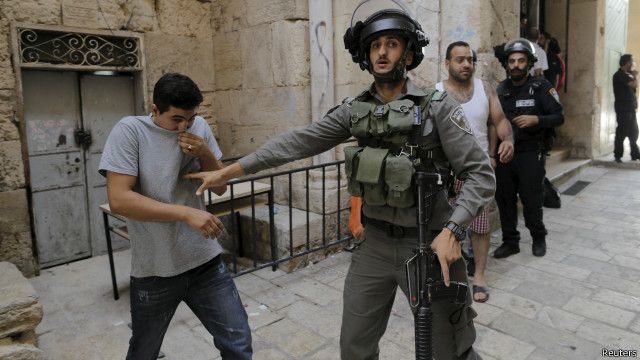 جندي إسرائيلي يمنع فلسطينيا من دخول المنطقة التي يقع فيها المسجد الأقصى.